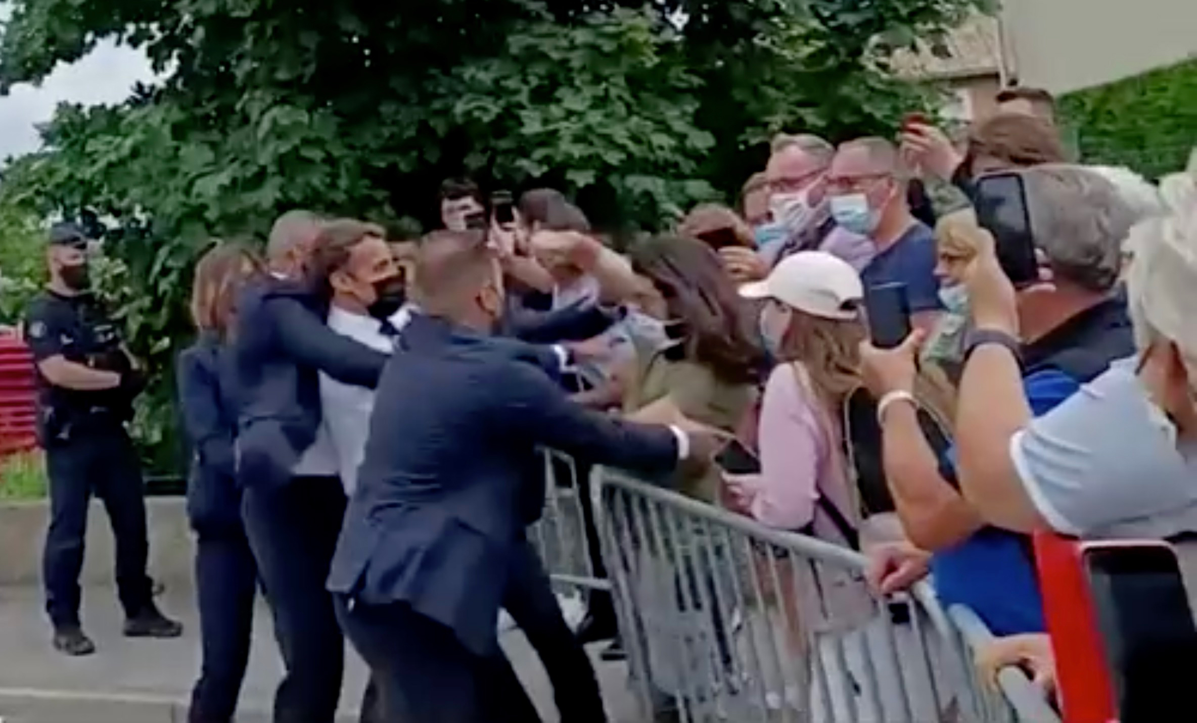 French President Emmanuel Macron is slapped in the face by a member of the public during a visit to Tain-l'Hermitage, France, June 8, 2021. BFMTV via Reuters TV