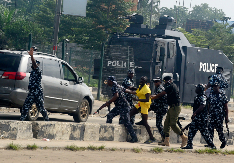 Anti-riots policemen detain a protester during a demonstration at Ojota in Lagos on June 12, 2021, as Nigerian activists called for nationwide protests over what they criticise as bad governance and insecurity, as well as the recent ban of US social media platform Twitter by the government of President Muhammadu Buhari. - Hundreds of protesters gathered on June 12, 2021 in Lagos, a sprawling megapolis of over 20 million people, and police fired tear gas to disperse the crowd. (Photo by PIUS UTOMI EKPEI / AFP)