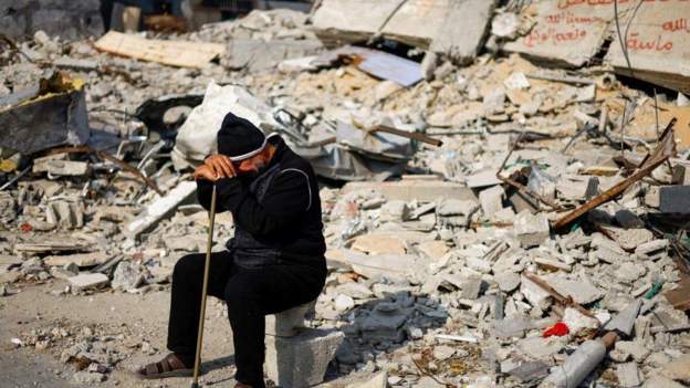 A Palestinian man mourns in a bombarded site/Reuters