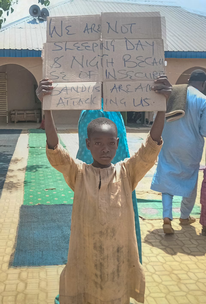 Boy holds a sign protesting insecurity and banditry attacks in Kaduna State/Reuters