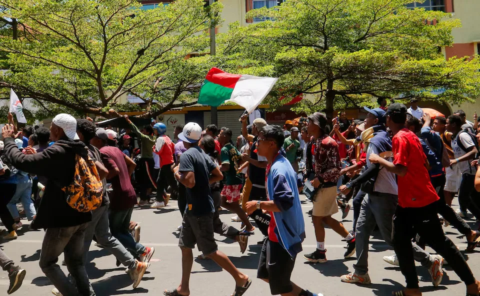 Demonstrators wave Madagascar's national flag while running through Antananarivo's Independence Avenue during a countrywide protest led by young people against recurring electricity cuts and inadequate water supply, on October 13, 2025. REUTERS/Zo Andrianjafy