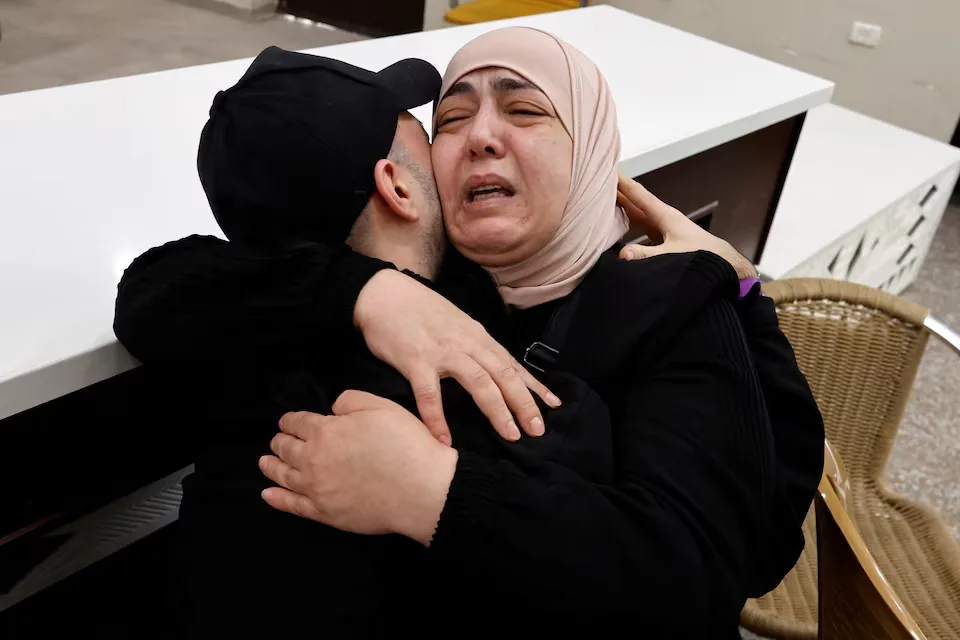 A released Palestinian prisoner embraces a family member following his release from Israeli detention as part of a hostage-prisoner exchange agreement and Gaza ceasefire between Hamas and Israel, photographed in Ramallah in the Israeli-occupied West Bank on October 13, 2025. REUTERS/Ammar Awad