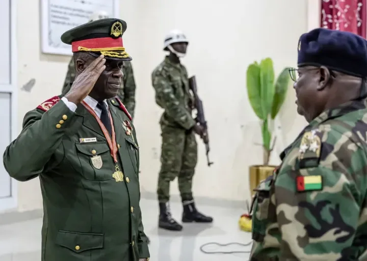 On Thursday, November 27, 2025, General Horta Inta-A of Guinea-Bissau salutes an officer at his swearing-in ceremony in Bissau, where he assumed the role of transitional leader and head of the High Command [Patrick Meinhardt/AFP]