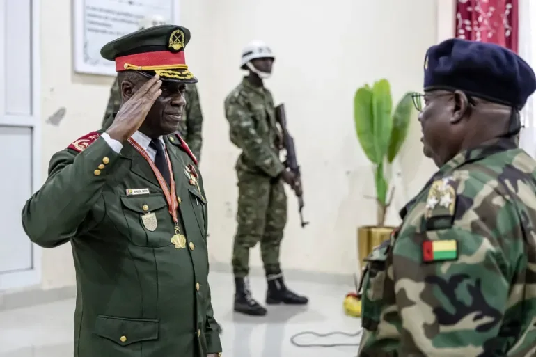 On Thursday, November 27, 2025, General Horta Inta-A of Guinea-Bissau salutes an officer at his swearing-in ceremony in Bissau, where he assumed the role of transitional leader and head of the High Command [Patrick Meinhardt/AFP]