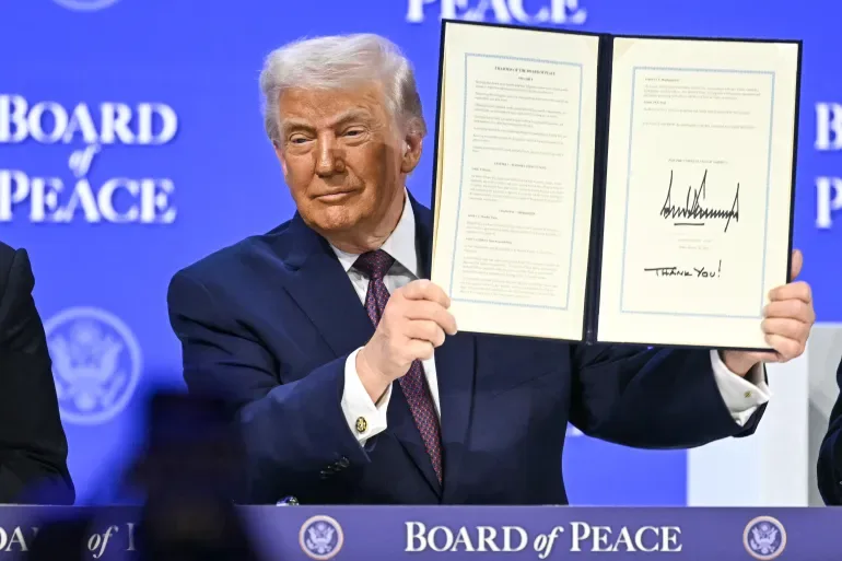 Donald Trump, the US President, displays a signed founding charter for the Board of Peace at the World Economic Forum in Davos, Switzerland, on January 22, 2026 [AFP]