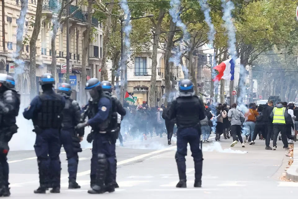 Protesters scatter as tear gas is fired during a demonstration in Lyon, France, on October 24, 2026. The rally, organized by the “Yellow Vests” movement and joined by French high school and university students, was held in defiance of a ban by local authorities and aimed at the rising cost of living and fuel prices. REUTERS/Lisi Niesner