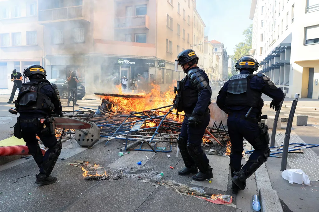 French CRS riot police clear parts of a burning street barricade in Lyon on October 6, 2026, as high school and university students joined a nationwide day of protests and blockades. The demonstrators are angry about overcrowded classrooms, teacher shortages and run-down school buildings, which they blame on years of underinvestment. REUTERS/Denis Balibouse